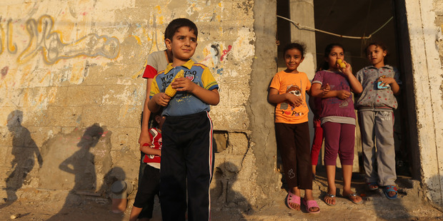 Palestinian children stand near their house eating corn at the Shati refugee camp, in Gaza City. Photo / AP