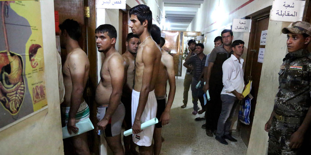 Iraqi men line up for physical examinations at the main army recruiting centre to volunteer for military service in Baghdad, Iraq. Photo / AP