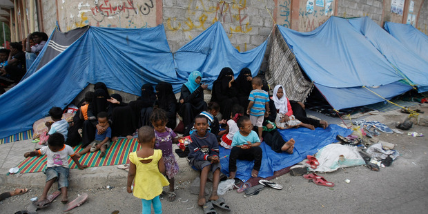 Eritrean female asylum seekers sit along with their children on the sidewalk in Sanaa, Yemen. Photo / AP