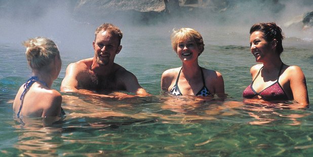 Taking the waters at Hot Water Beach, Lake Tarawera. Photo / Destination Rotorua