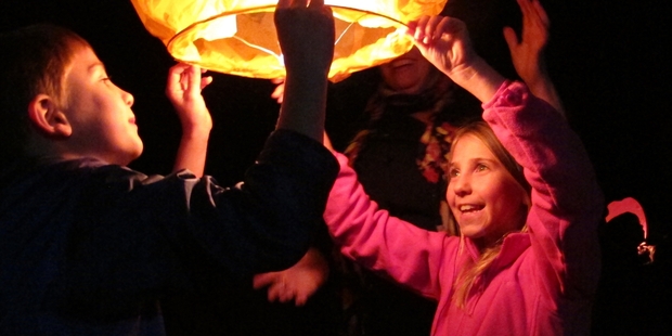 UP SHE GOES : Henry and Bella Kinnon get ready to release a flying lantern at last year's Oromahoe School Light Festival. PHOTO/PETER DE GRAAF