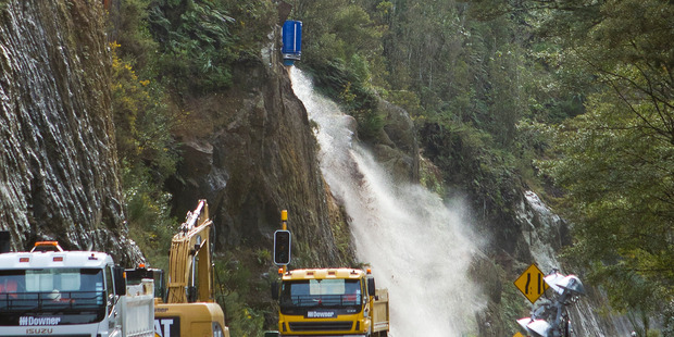 Workers flush out slip risks on State Highway 36 using thousands of litres of water dropped from a helicopter monsoon bucket. Photo / Ben Fraser