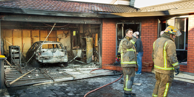 Fire officers at a house fire in Woodbury Street, Avonhead, Christchurch. Photo / Martin Hunter