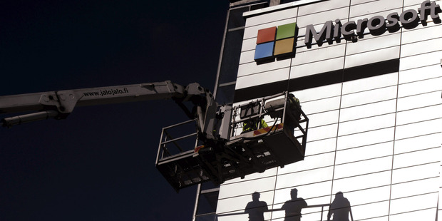Workers install the Microsoft logo on the wall of Nokia's former headquarters in Espoo, Finland. Microsoft has decided to use the Android operating system in its new Nokia smartphone. Photo / AP
