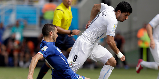 Italy's Leonardo Bonucci, left, tackles Uruguay's Luis Suarez during the group D World Cup soccer match between Italy and Uruguay. Photo / AP