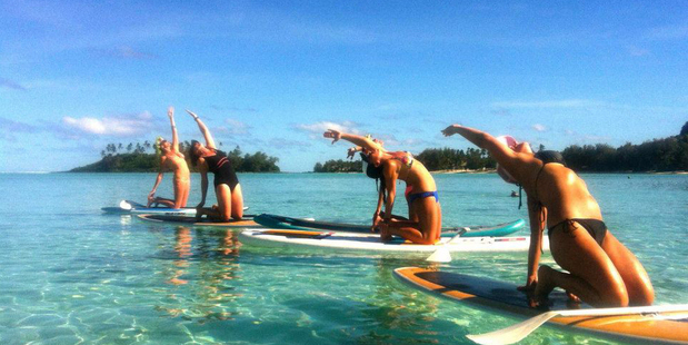 The warm waters of Rarotonga are the perfect base to experience yoga on a stand-up paddleboard. Photo / Supplied