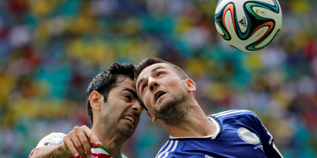 Iran's Pejman Montazeri, left, and Bosnia's Vedad Ibisevic battle for the ball. Photo / AP