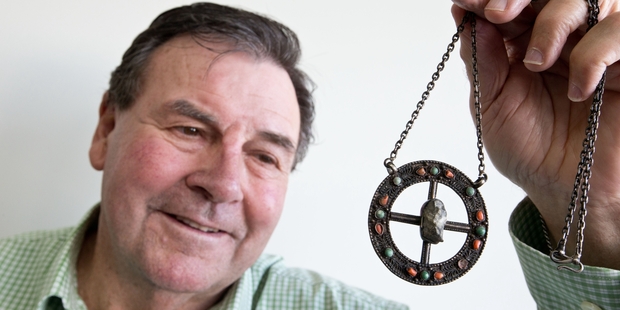 Auctioneer Dunbar Sloane with the brooch containing the stone. Photo / Richard Robinson