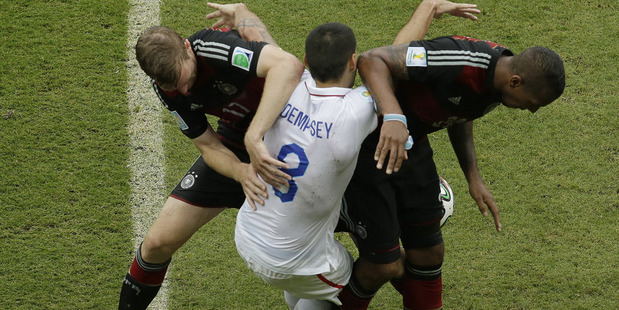 United States' Clint Dempsey gets tangled with Germany's Per Mertesacker, left, and Germany's Jerome Boateng. Photo / AP