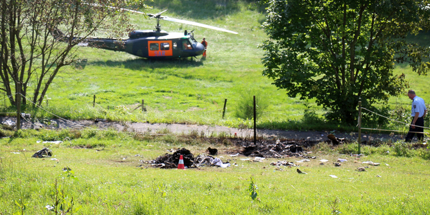 A helicopter lands near debris of a crashed Learjet near Elpe, Germany, which collided with a German Eurofigher. Photo / AP