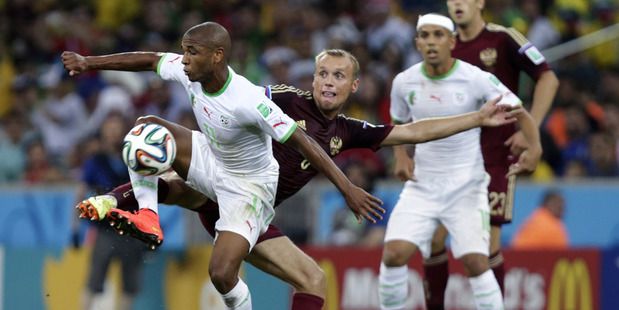 Algeria's Yacine Brahimi, left, and Russia's Denis Glushakov fight for the ball during their World Cup encounter. Photo / AP