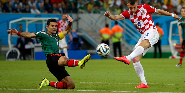 Croatia's Ivan Perisic shoots as Mexico's Rafael Marquez tries to block him. Photo / AP