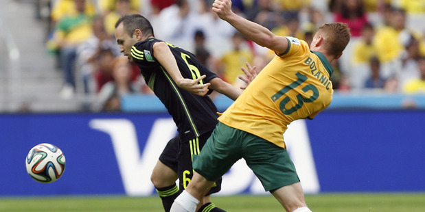Spain's Andres Iniesta, left, holds off Australia's Oliver Bozanic. Photo / AP