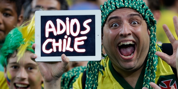An ecstatic Brazilian supporter holds up a message for their beaten opponents after his side won. Photo / AP