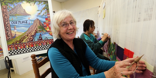 Beverly Compter working on the large tapestry at The Bach in Whangarei, with her assistant Naoko Watson in the background. Behind them is the artist's design of the community-created piece. Photo/John Stone