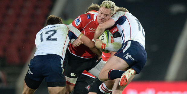 Alwyn Hollenbach of the Lions, centre, is tackled during the Super Rugby match between Lions and Melbourne Rebels at Ellis Park in Johannesburg. Photo / Getty Images