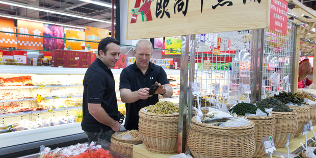 Gore farmer Michael Wilkins, left, and BNZ agribusiness client director Nathan Henry viewing products in the Shanghai Auchen supermarket. Photo / Mark Mitchell