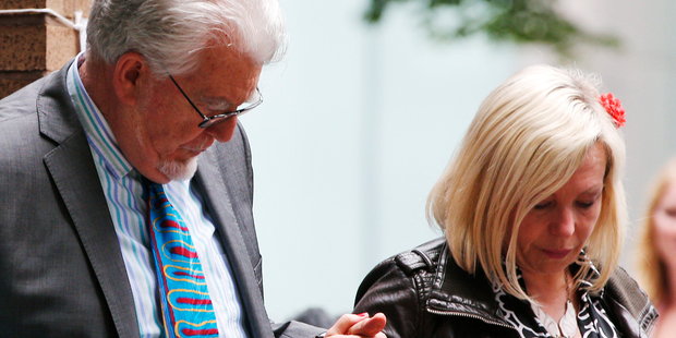 Veteran entertainer Rolf Harris holds the hand of his daughter Bindi, as they leave Southwark Crown Court following his guilty verdict. Photo / AP