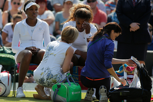 Court officials talk to Serena Williams and Venus Williams, left, of the U.S as they retire after 3 games from their women's doubles match. Photo / AP