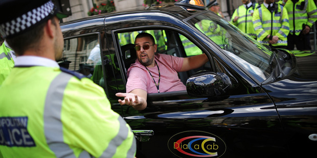 A London taxi driver talks to police during a protest against Uber. Photo / Getty Images