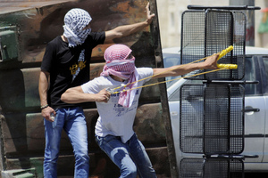 A Palestinian uses a sling shot during clashes with Israeli border police in Jerusalem. Photo / AP