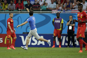 A pitch invader runs as Belgium players look at him. Photo / AP