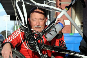 Cyclist Pascal Sutherland holds his bike, which was damaged when a motorist ran over it on Saturday. Photo / Craig Baxter / Otago Daily Times