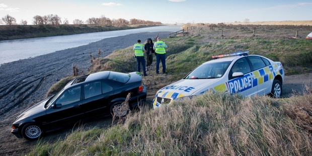 Police talk to one of the occupants of a car after a pursuit led a man to swim across the Ngaruroro River. Photo/Glenn Taylor