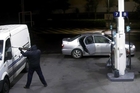 The masked man, who arrived in the silver Nissan in the background, points a gun at the Armourguard van window and demands money. The masked man, who arrived in the silver Nissan in the background, points a gun at the Armourguard van window and demands money.