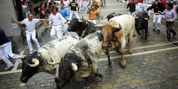 Participants run behind Torrestrella's bulls during the first bull-run of the San Fermin Festival. Photo / AFP