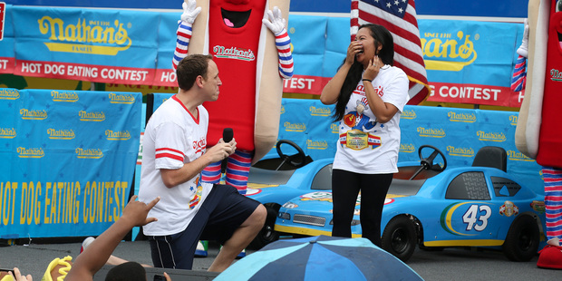 Competitive eater Joey Chestnut proposes to his girlfriend and fellow competitor Neslie Ricasa before the Famous Fourth of July International Hot Dog Eating contest.
Photo / AP