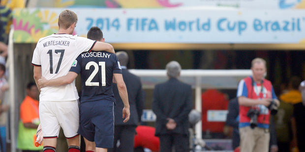 Germany's Per Mertesacker and France's Laurent Koscielny leave the pitch arm in arm at the end of the World Cup quarterfinal soccer match. Photo / AP