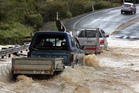Flooding and storm damage in the mid-north - vehicles heading north through flooding at the base of Turntable Hill, Moerewa. Flooding and storm damage in the mid-north - vehicles heading north through flooding at the base of Turntable Hill, Moerewa.