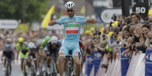 Italy's Vincenzo Nibali points to his shirt as he crosses the finish line ahead of the sprinting pack to win the second stage of the Tour de France. Photo / AP