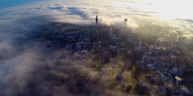 Auckland City centre is covered in a thick blanket of fog yesterday morning. Photo / Omnicron Productions