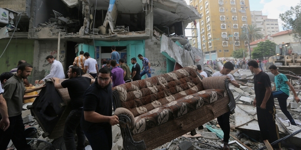 Palestinians retrieve their possessions after a rocket struck an apartment block in Gaza City. Photo / AP