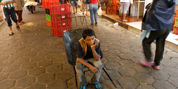 A 12-year-old boy who did not want to give his name rests as he works as a porter at the El Abasto market in Santa Cruz, Bolivia. Photo / AP
