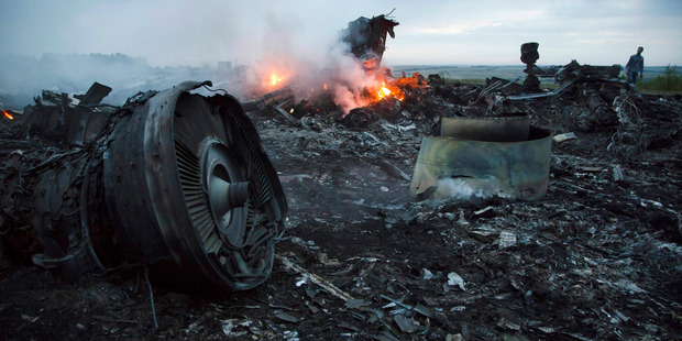 A man walks amongst the debris at the crash site near the village of Hrabove, Ukraine. Photo / AP