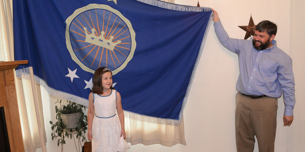 Jeremiah Heaton and his seven year-old daughter, Princess Emily, show the flag that their family designed as they try to claim a piece of land in east Africa. Photo / AP