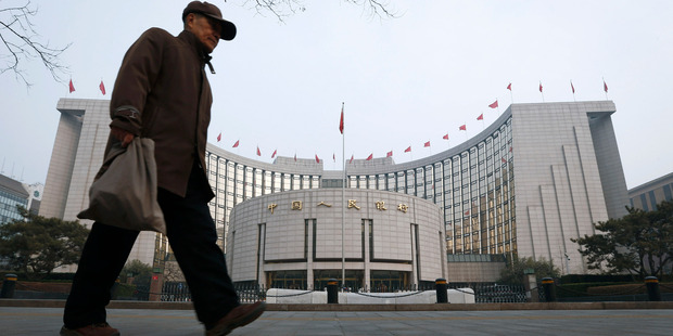 An elderly Chinese man walks past the headquarters of the People's Bank of China in Beijing. Photo / AP
