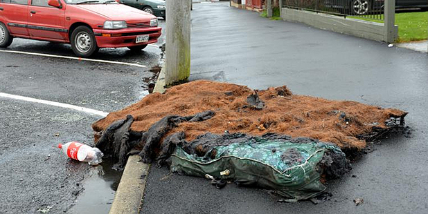 A burnt mattress lies in Howe St in Dunedin yesterday afternoon. Photo / Peter McIntosh.