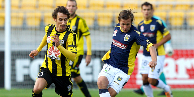 Nick Fitzgerald of the Mariners controls the ball under pressure from Albert Riera of the Phoenix. Photo / Getty Images.