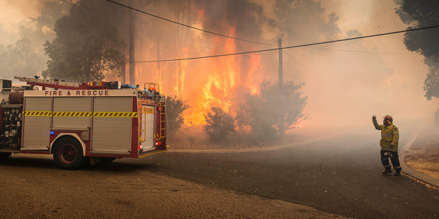 A firefighter directs a fire truck in Perth Hills in western Australia. Photo / AP
