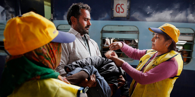 An Indian medical volunteer administers polio immunization drops to a child at a railway station in Allahabad, India. Photo / AP