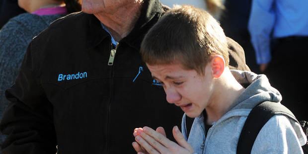 A student, right, waits at a staging ground area set up at the Roswell Mall. Photo / AP