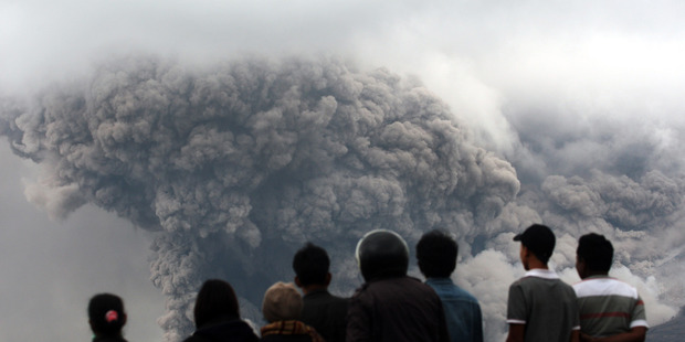 Villagers watch as Mount Sinabung releases pyroclastic flow during an eruption in North Sumatra, Indonesia. Photo / AP