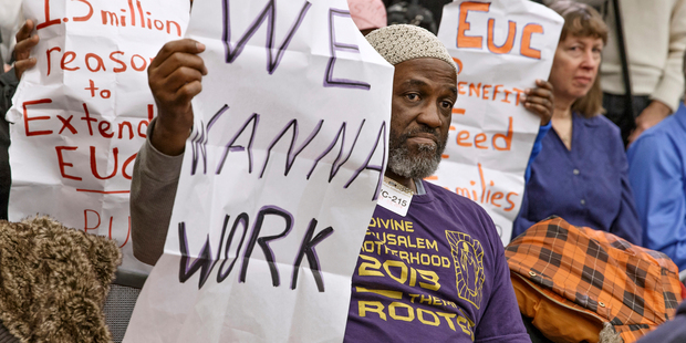 Audience members hold signs appealing for jobs as they attend a Democratic news conference about extending unemployment insurance benefits which expired on December 28. Photo / AP