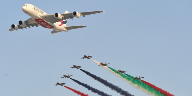 An Emirates' Airbus A380 passes over Dubai Air Show, flanked by the UAE Air Force Al Forsan team in November. Business is booming for Airbus, with a record 1,619 orders on its books. Photo / AP