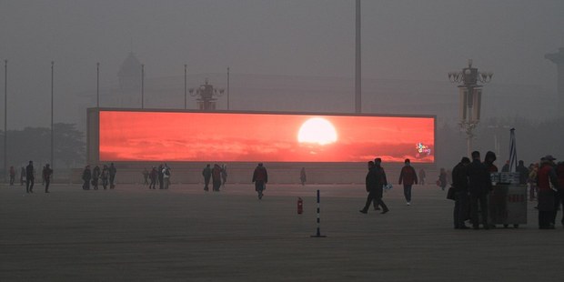 The LED screen shows the rising sun in Tiananmen Square which is shrouded with heavy smog. Photo / Getty Images