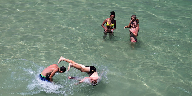 Teenagers cool off in the ocean during a heat wave at Glenelg beach. Photo / Getty Images